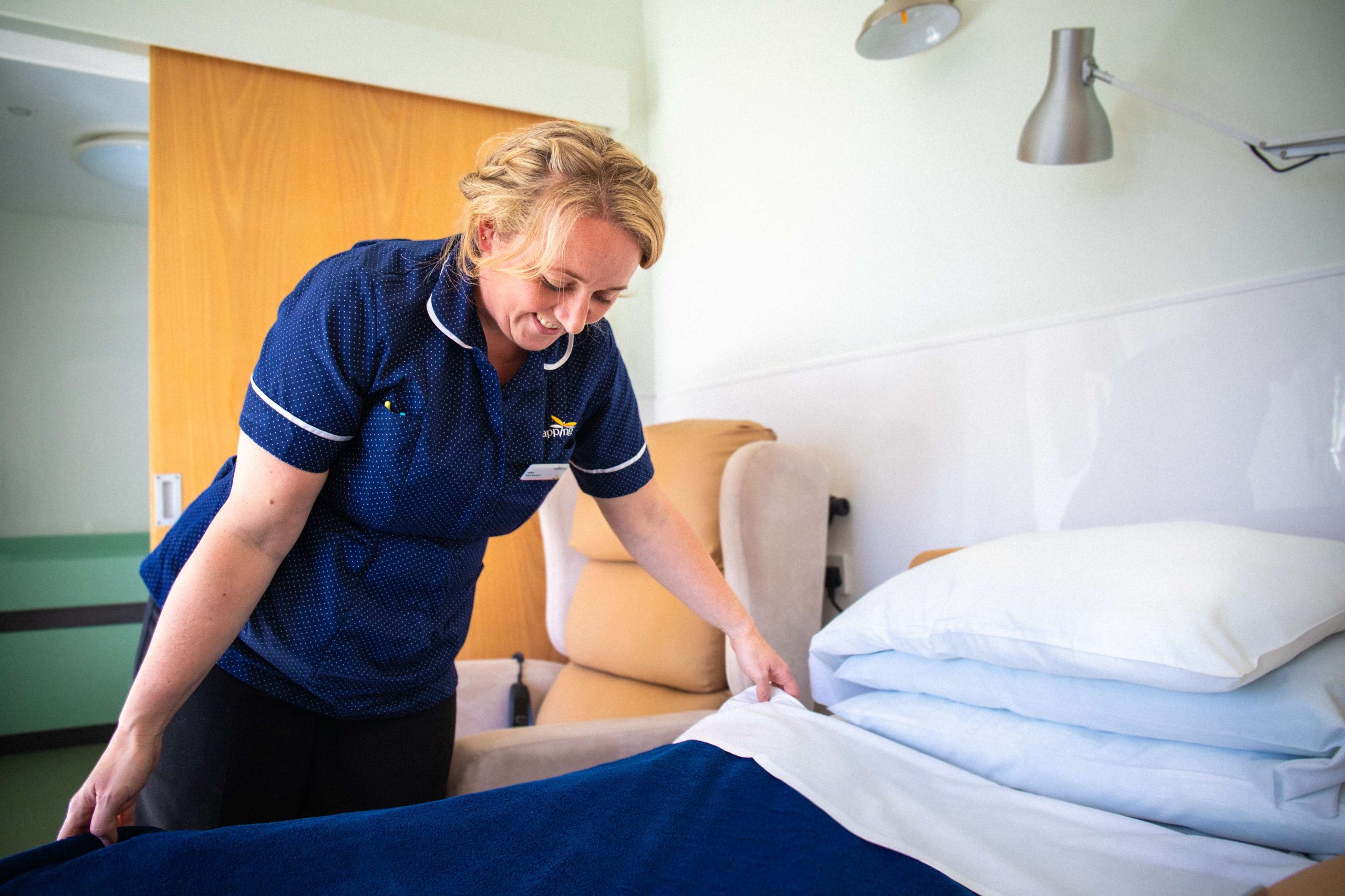 IPU nurse making bed at Tapping House Norfolk Hospice Charity
